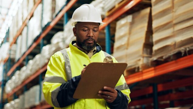 Black man, supervisor and clipboard at warehouse with counting or checklist, stocktake and delivery. Male person, employee and manufacturing for supplier in supply chain, logistics and wholesale.